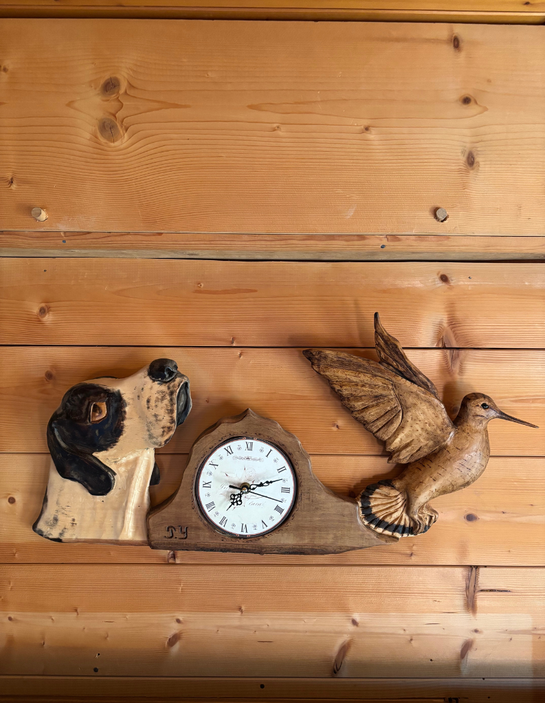 Horloge en bois sculptée avec un chien et un pivert