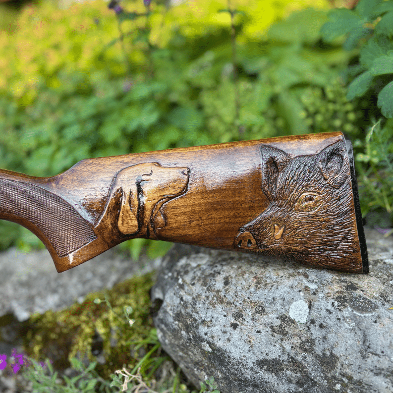 Crosse de fusil de chasse sculptée représentant un chien et un sanglier