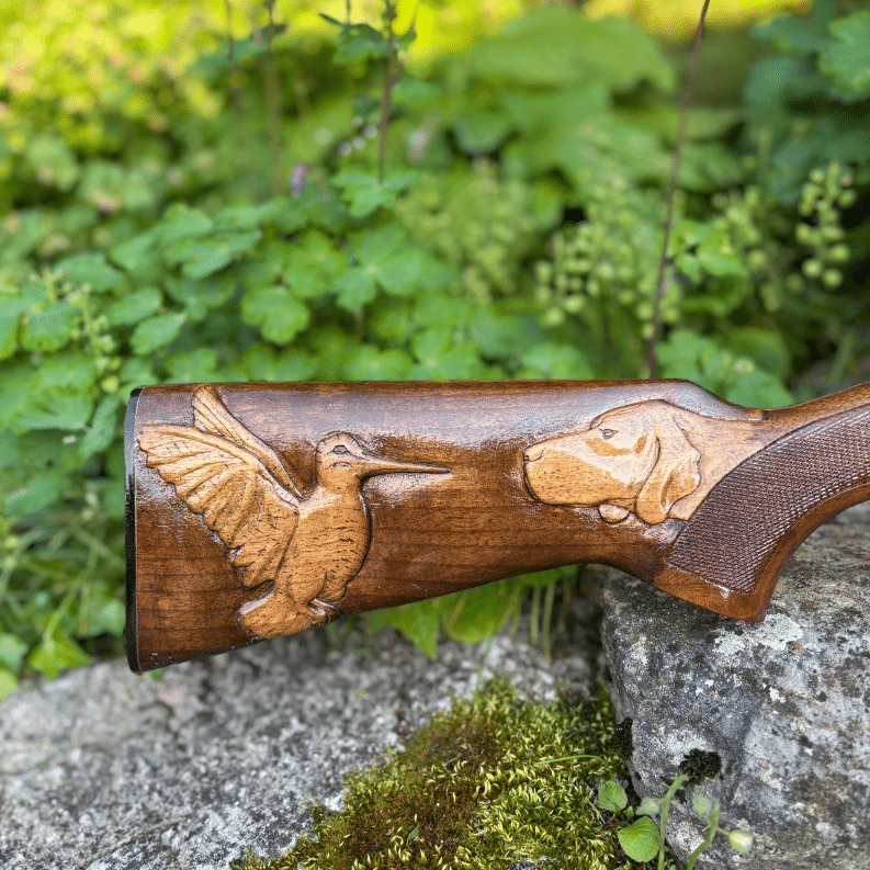Crosse de fusil de chasse sculptée représentant un chien et un oiseau